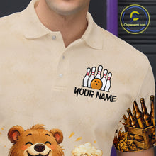 Load image into Gallery viewer, Beige polo shirt with various designs including a bear, bowling pins, and a beer mug.