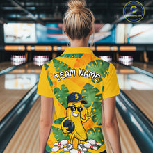 Load image into Gallery viewer, Woman in a bowling alley wearing a bright yellow tropical polo shirt with green leaf patterns, custom team name text, and a smiling banana mascot holding a bowling ball.