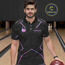 Load image into Gallery viewer, Man wearing a black bowling shirt with colorful designs and text on a bowling alley background.
