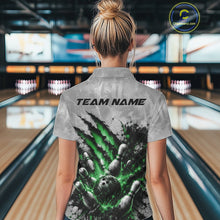 Load image into Gallery viewer, Back view of a female model wearing a gray bowling polo shirt featuring a dramatic green bowling ball and pins graphic with claw-mark artwork in a bowling lane.