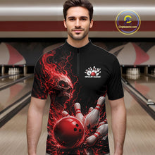 Load image into Gallery viewer, Front view of a male model in a bowling alley wearing a black bowling quarter zip shirt featuring a red fiery skull design with lightning striking a bowling ball and pins and a custom name.
