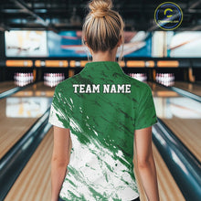 Load image into Gallery viewer, Back view of a female model in a bowling alley wearing a bowling polo shirt featuring a white paint splatter distressed design on a green shirt.
