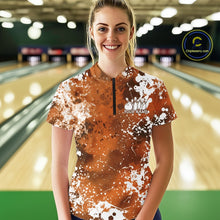 Load image into Gallery viewer, Front view of a female model in a bowling alley wearing a bowling quarter-zip shirt featuring a white paint splatter design on an orange sportswear shirt.
