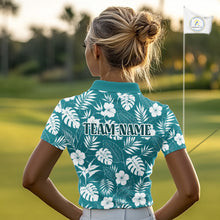 Load image into Gallery viewer, Woman wearing a teal floral patterned golf shirt with 'TEAM NAME' on a golf course